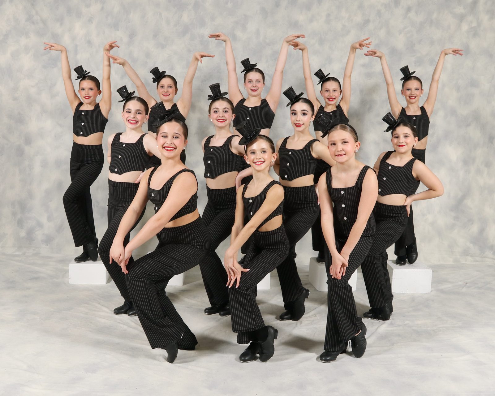 AYDC dancers in pinstripe Fosse-style costumes and top hats